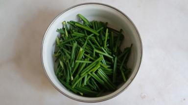 韭菜花择去根部，洗干净，切成小段。
