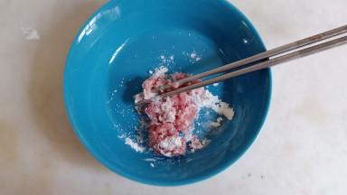 猪肉沫加淀粉、盐、少许清水拌匀，腌渍十五分钟。