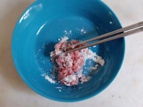 猪肉沫加淀粉、盐、少许清水拌匀，腌渍十五分钟。