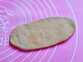 取一块醒发好的面团，用擀面杖擀成椭圆形。