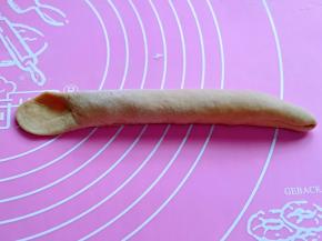 再搓成圆柱形，一边尖，一边压扁，如图。