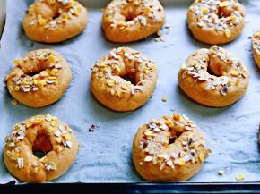 将红糖贝果放在垫有油纸的烤盘上，撒上燕麦片。