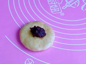 取一块面团，擀面杖擀成圆饼，加入豆沙馅。(豆沙馅的量可以根据个人喜欢来，我放的少）