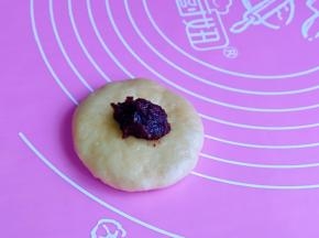 取一块面团，擀面杖擀成圆饼，加入豆沙馅。(豆沙馅的量可以根据个人喜欢来，我放的少）