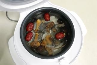 加入姜片、香菇、松茸、茶树菇、红枣和山药，倒入适量的清水，建议不要超过最高水位线。