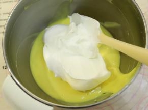 先取三分之一的蛋黄糊和蛋白混合，上下翻拌均匀。