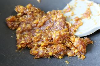 中小火不停翻炒至凤梨馅抱团，用锅铲压拌时有阻力，有弹性后关火，摊开放凉。