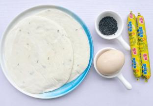 食材：手抓饼皮2片，火腿2根，鸡蛋1个，黑芝麻适量。