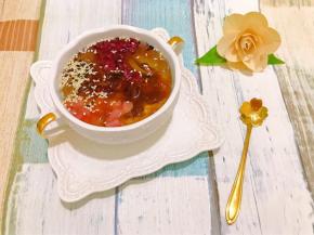 取出凝固的冰粉舀入碗里，加上自己喜欢的配料我用了蜜桃粒，紫米酒酿（酒酿真的超配冰粉的）熟黑白芝麻，淋上红糖水就可以啦