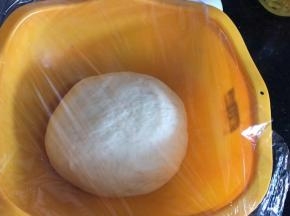 取出面团滚圆，放入大点的容器中，密封发酵至两倍以上