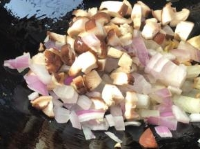 放入洋葱和香菇，翻炒均匀至变软