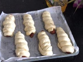 放入铺好油纸的烤盘上，密封发酵至两倍大