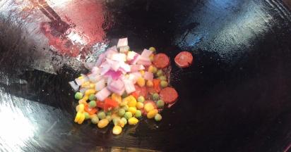 倒入洋葱丁和三色丁，翻炒均匀