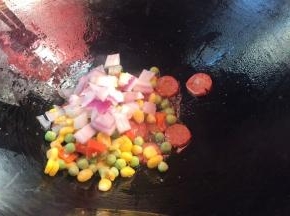 倒入洋葱丁和三色丁，翻炒均匀