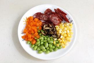 干香菇提前泡发好，腊肠和香菇切片，胡萝卜去皮切丁，玉米粒掰下来和豌豆冲洗干净。