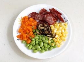 干香菇提前泡发好，腊肠和香菇切片，胡萝卜去皮切丁，玉米粒掰下来和豌豆冲洗干净。