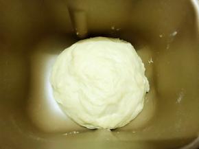 取下面包机的搅拌刀，把滚圆的面团放入面包桶里进行二发