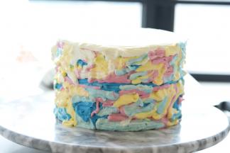 蓝色奶油在蛋糕体的三分之二高度挤一圈，其它的颜色随意填满整个蛋糕胚。