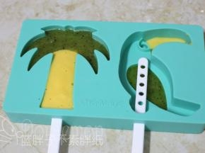将它们分别装入裱花袋。椰树的叶子做猕猴桃口味，树干芒果口味。同时将两者口味的果汁挤入模具中即可。