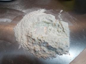 把筛好的面粉倒在面垫上，预留出少许面粉调整硬度，然后把面粉堆成小山坡，中间掏空，把第二部做好的液体倒入，用刮板一点点把面粉撒入，慢慢融合，直至慢慢融合成一块面团。