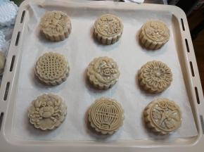 依次做好全部月饼，直接摆在烤盘上面，预留一定空隙，把圆球放在模子内，月饼模直接按在烤盘上，速度压出月饼花纹，马上抬起模子，就完成了。
