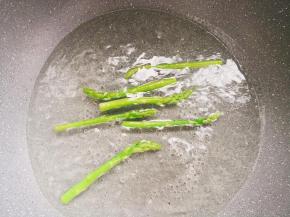 锅中倒水烧开，倒入几滴油和少许盐调匀，放入芦笋焯水断生。