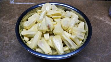 戴上一次性手套，刀抹上食用油切开大树菠萝，拿出菠萝蜜肉出来