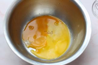 2个蛋黄放入打蛋盆中，牛奶放在奶锅中煮沸