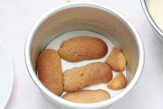 手指饼干在咖啡酒里面滚一圈，摆入6寸圆模底部，再倒入1/3的慕斯糊