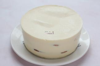 冷藏后的提拉米苏从冰箱取出，用热毛巾捂一圈模具，将提拉米苏蛋糕脱模取出