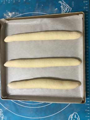 全部做好后摆在铺有油纸的烤盘上，盖保鲜膜放温暖处进行二发。