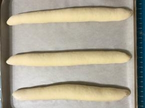 全部做好后摆在铺有油纸的烤盘上，盖保鲜膜放温暖处进行二发。