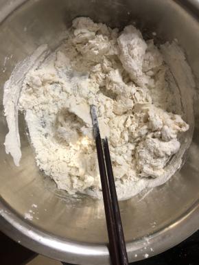 酵母水边倒边搅拌，把面粉搅拌成絮状。