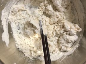 酵母水边倒边搅拌，把面粉搅拌成絮状。