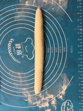 从左到右给它卷起来，收口朝下。并给它搓长一些。