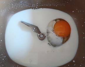 面包机先放入纯牛奶和鸡蛋。