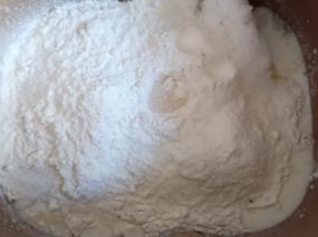 再放入全麦粉和高筋面粉，对角放盐和糖，中间挖个洞放入酵母。