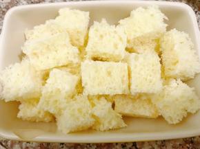 吐司切去四边后，改刀成小块放入烤碗里