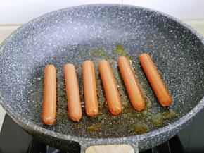 起油锅，将火腿肠摆放在平底锅中。