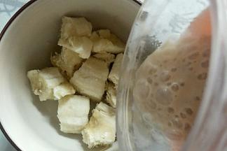 把另一个香蕉掰碎放入碗中，榨好的酸奶倒入碗中。