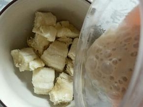 把另一个香蕉掰碎放入碗中，榨好的酸奶倒入碗中。