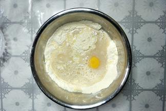把酵母水倒入面粉中，打入一个鸡蛋