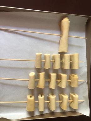 串好的豆腐皮串摆放在铺有油纸的烤盘上。