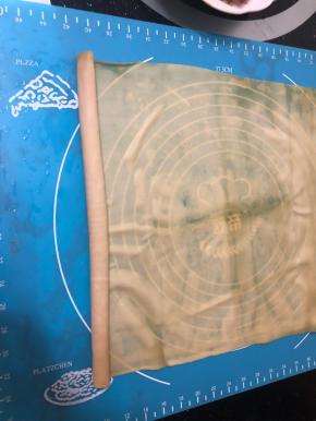 平铺在案板上，从一边开始卷起来，卷得紧一点。