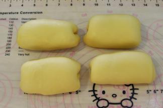 将面团轻压排气后平均分成4份，不用搓圆，直接折叠成椭圆形。