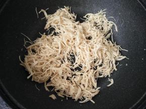 平底锅倒入适量色拉油，倒入鸡肉丝小火不断翻炒。