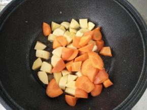 锅里再放入少许油，将土豆和胡萝卜倒入翻炒。