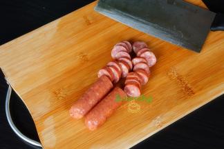 牛肉肠从冰箱取出，不需解冻直接切片，厚度适中。太厚煎不香，太薄口感不好。