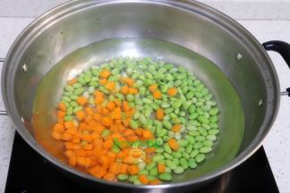 清水煮沸，把切好的胡萝卜粒，毛豆倒入锅里少许盐，汆烫熟，捞出，放凉。