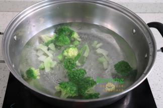 煮锅再次倒入适量的水煮沸之后，倒入切好的西兰花，汆烫熟，捞出过冷水，过冷水可以让西兰花颜色翠绿，爽口好吃。